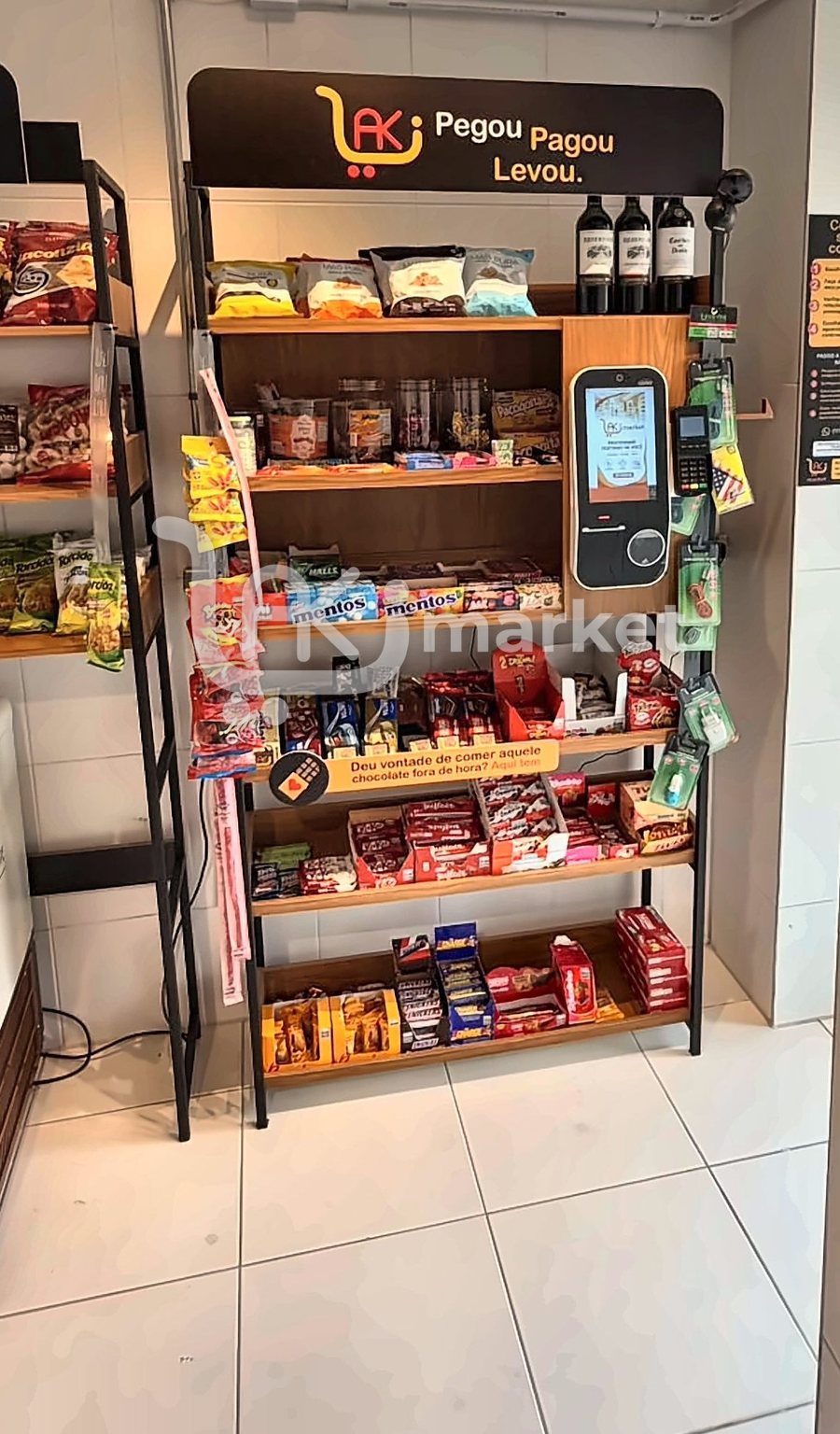 Expositor Pegou, Pagou, Levou com o totem de autoatendimento, a máquina de cartão, doces e vinhos.